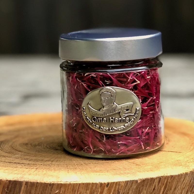 Kornblumenblütenblätter in rot getrocknet im Glas als essbare Blüten zum Dekorieren von Speisen