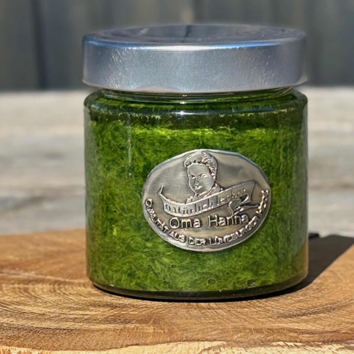 Wildkräuterpesto Gartengeflüster im Glas auf Holzteller